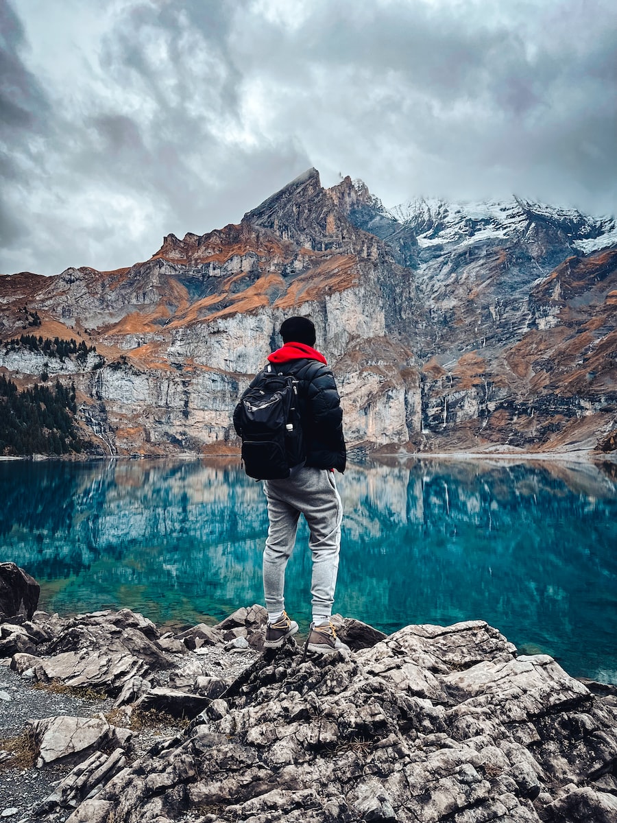 a person standing on a rocky shore looking at a body of water
