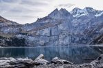 body of water near mountain during daytime