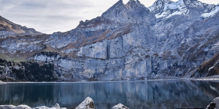 body of water near mountain during daytime