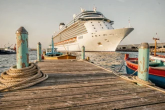 Quai du port de Sète avec bateau de croisière amarré et bateaux de pêche colorés au premier plan