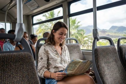 Jeune femme souriante dans un bus à la Réunion avec carte
