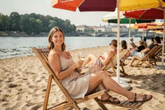 Femme se relaxant sur la plage urbaine de Vienne au bord du Danube avec un verre de vin blanc